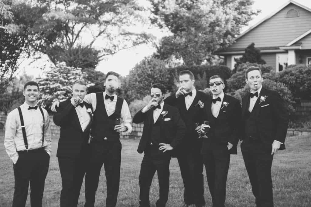 Groom and Groomsmen Smoking Cigars Vineyard Wedding